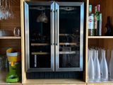 de nombreuses bouteilles et verres sur les étagères de la cuisine
