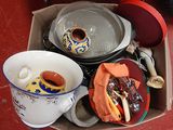 une boîte remplie d'ustensiles de cuisine posée par terre