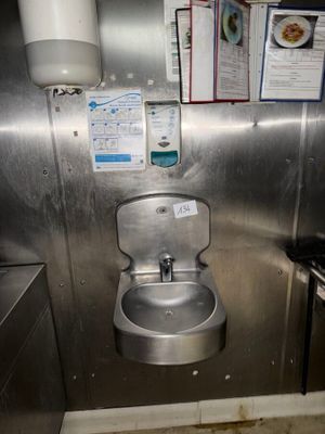 a small bathroom with a stainless steel toilet and sink