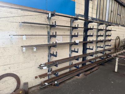 a wall of metal pipes in a warehouse with a blue wall