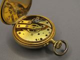 une montre de poche en or à laquelle est attachée une chaîne