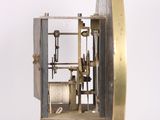 a clock that is sitting on a stand on a white surface