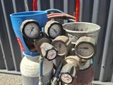 a stack of propane gas cylinders with gauges on them