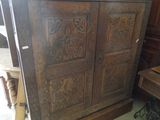a large wooden cabinet with carvings on the doors