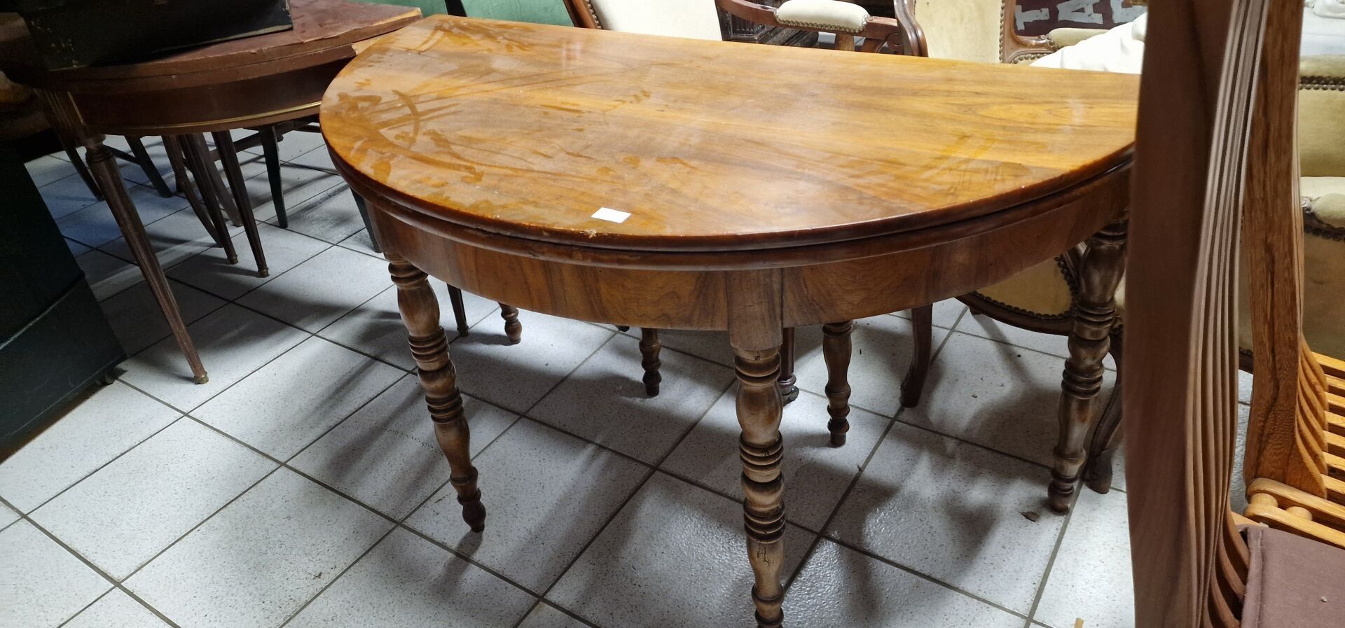 Table demi-lune en noyer. Dimensions : Hauteur : 75 cm.