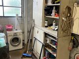 a dirty kitchen with a washer and dryer in it