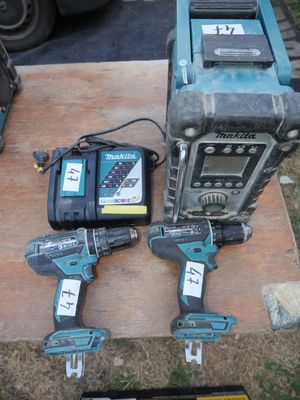 two corded drillers sitting on top of a piece of wood