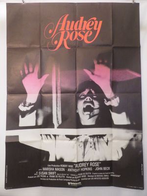 une vieille affiche de cinéma représentant une femme les mains levées en l'air