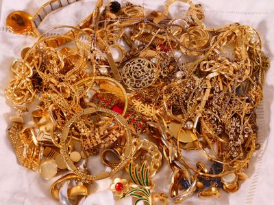 a pile of gold jewelry sitting on a white cloth