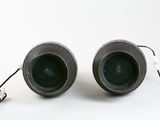 two black vases sitting next to each other on a white surface