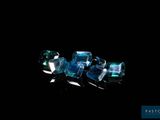 some very pretty blue crystals sitting on top of a black surface