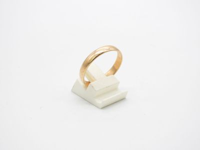 une bague en or posée sur un bloc de marbre blanc