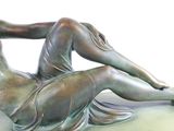 a bronze statue of a woman laying on the ground