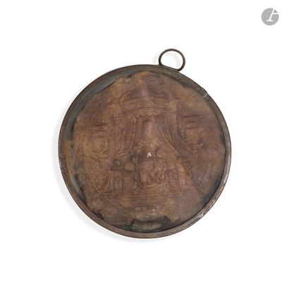 une photo d'un médaillon en bronze sur un mur blanc