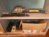 un petit train miniature posé sur une étagère à côté d'une boîte