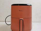 an orange air fryer sitting on top of a white counter