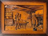 des sculptures représentant un homme et une femme dans une cuisine, dans un cadre en bois