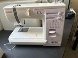 a white sewing machine sitting on a table in a room