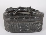 statue of a woman laying down on a box with a bird on it