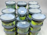 many buckets of tennis balls sitting on a table