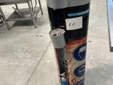 une canette de soda posée par terre à côté d'une poubelle
