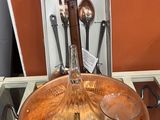 une assiette en cuivre sur laquelle sont posées des cuillères et des ustensiles