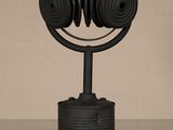 une sculpture noire représentant un casque audio posé sur une canette