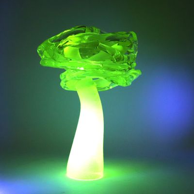 une lampe verte en forme de champignon posée sur une table