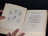une personne tenant un livre ouvert sur lequel figurent des images