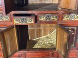 a wooden cabinet with two doors open and a cushion in the middle