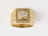 gros plan d'une bague en or avec un diamant au centre