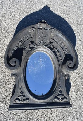 un miroir fixé sur le mur d'un immeuble, dans lequel se reflète le ciel