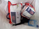 two bags of toiletries and a bottle of water on a bed