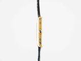 an image of a close up of a black cord with a gold clasp