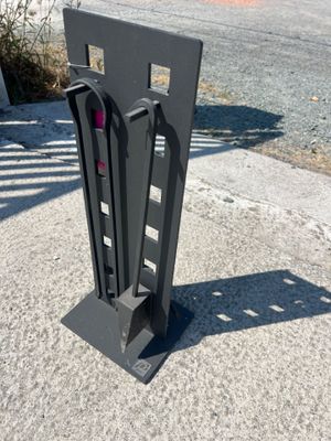 un objet métallique noir sur le trottoir, près de la rue