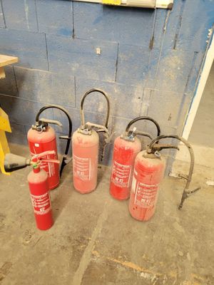 several fire extinguisors are lined up in a room