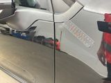 a man that is standing next to a silver car