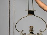 a person holding a lamp and a candle holder