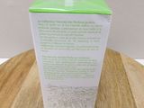 a green container on a wooden table with a white background