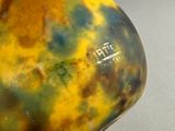 a yellow and green vase sitting on top of a table
