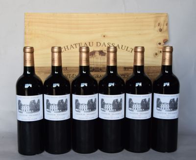 six bouteilles de vin rouge sont posées devant une caisse en bois
