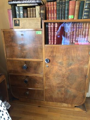 une commode surmontée d'une étagère, dans une pièce