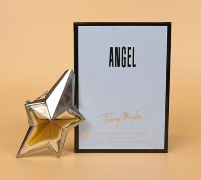 an angel perfume bottle next to a box with a star on it