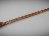an old wooden stick with writing on it sitting on a table
