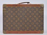 an old louis vuitton suitcase sitting on top of a white surface