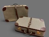 two pieces of luggage sitting next to each other on a gray surface