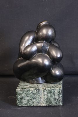a sculpture of a bunch of black balls on a marble base
