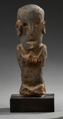 un gros plan d'une statue représentant un homme posée sur un socle en bois