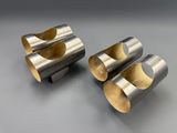 two silver and gold napkin holders on a gray surface