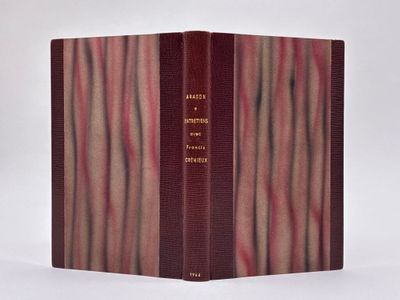 un vieux livre à la couverture rouge posé sur une table blanche